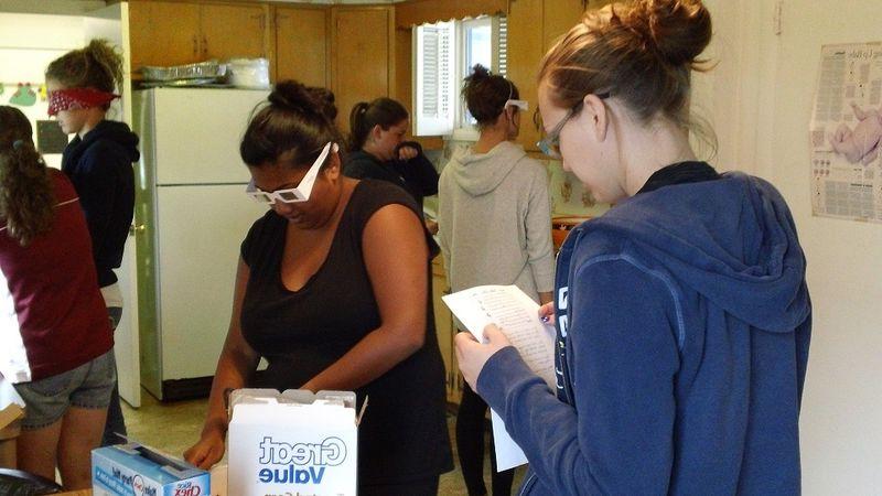 OT 107的学生完成一个低视力模拟活动.  这就要求他们在被诊断为低视力的时候准备一份零食.  This lab is completed in the OT House kitchen.
